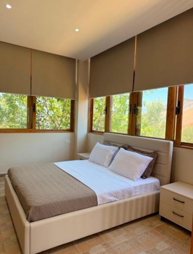 a bedroom with a large bed with windows at Castle View in Qeparo