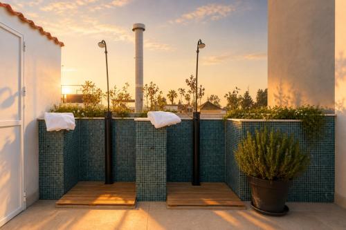 a bathroom with a green tiled fence with two towels at Posada de los Venerables in Seville