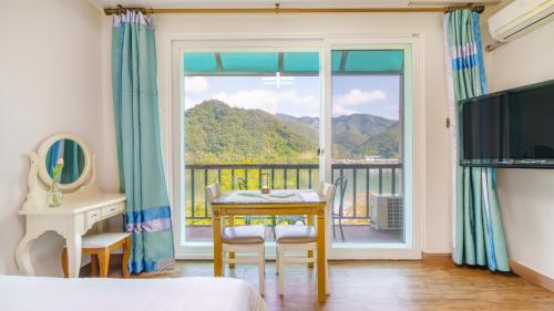 a bedroom with a table and a large window at Gapyeong Elin Pension in Gapyeong