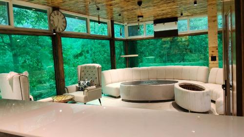 a living room with a couch and a large window at Cottages & Cafe in Dogadda