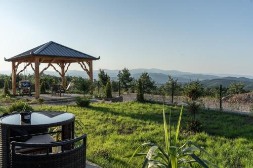 a gazebo in a field with a table and chairs at Golden view Villa in Prishtinë