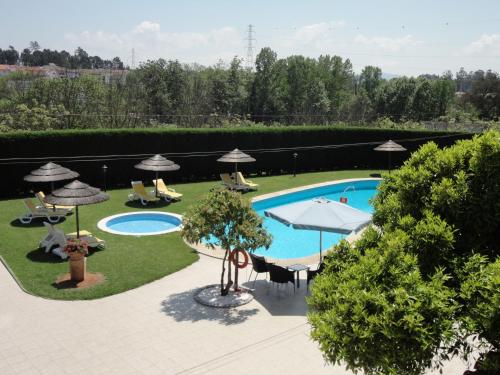 an outdoor swimming pool with chairs and umbrellas at Agroturismo Quinta Dom José in Braga