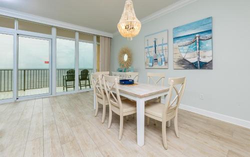 a dining room with a white table and chairs at Phoenix Gulf Towers 706 condo in Gulf Shores