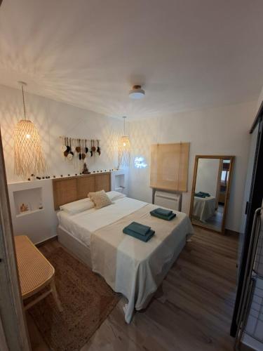 a bedroom with a large white bed and a mirror at Refugio Bella Luna in Ruidera
