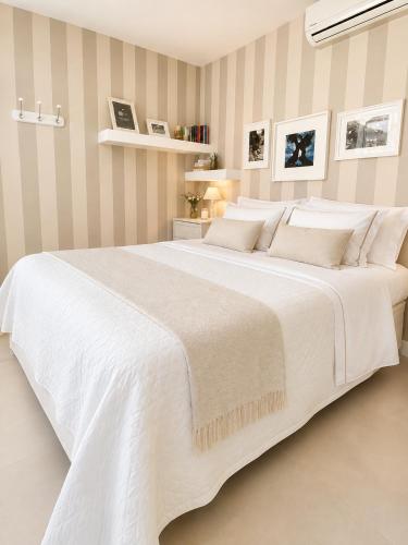a white bedroom with a large white bed at Bari LandLord 31- Old Town Apartment in Bari