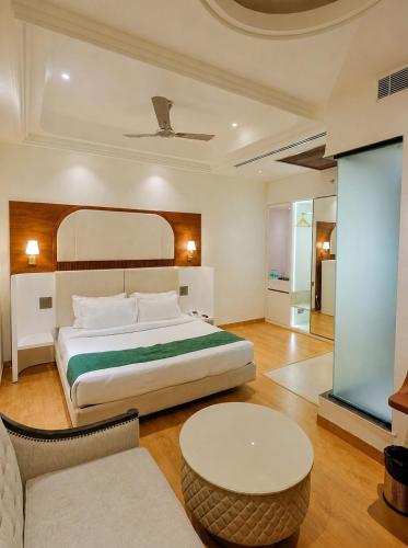 a bedroom with a large bed and a table at Hotel Pacific Primee in Zirakpur
