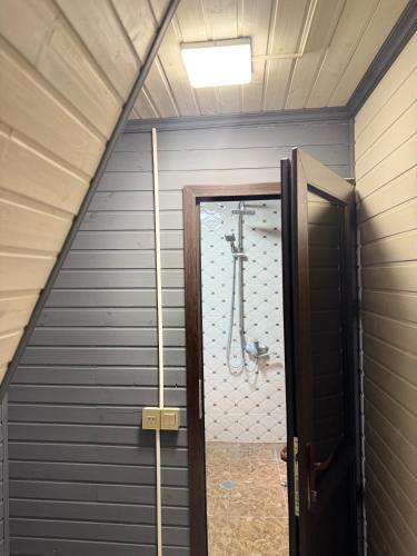 a bathroom with a shower and a door in a room at Damla in İsmayıllı