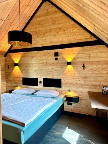 a bedroom with a bed in a wooden wall at Chalet Muckelstübchen in Bad Arolsen