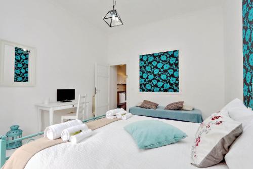 a white bedroom with a bed and a couch at Charming Apartment Antonia 300 mt from Colosseum in Rome