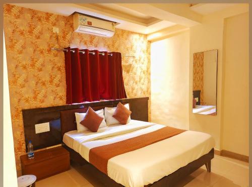 a bedroom with a bed with a red curtain at Udupi Grand Lodging and Boarding in Chākan
