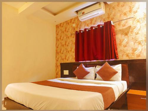 a bedroom with a bed with a red curtain at Udupi Grand Lodging and Boarding in Chākan
