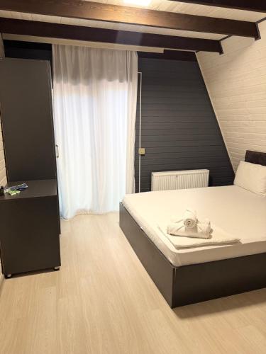 a bedroom with a bed and a window at Damla in İsmayıllı