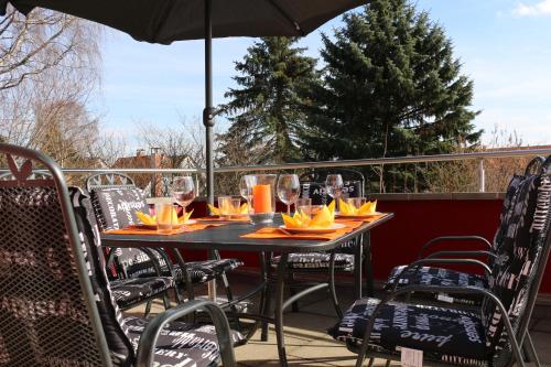 a table with chairs and wine glasses on a patio at Ferienhaus SweetHome - eingezäunter Garten - 3 Hunde willkommen - ruhige Sackgasse in Bad Sachsa
