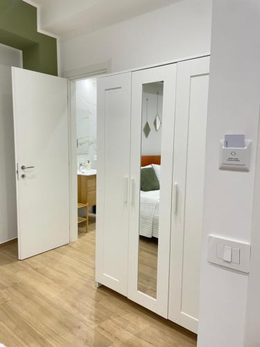 ein Zimmer mit weißen Schränken und ein Schlafzimmer in der Unterkunft Marylen in Gela