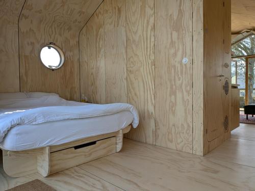 a bedroom with a bed with a wooden wall at Bakkums Bosgeluk in Castricum