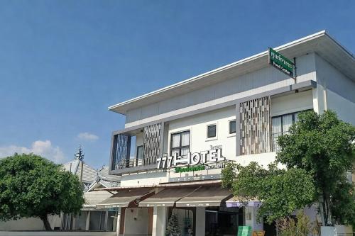 a white building with a sign on top of it at 777 Food & Bed in Chiang Rai