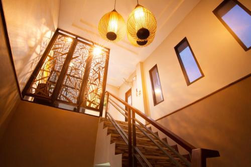 a hallway with a staircase and two lights and windows at 777 Food & Bed in Chiang Rai
