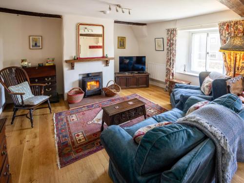 a living room with a couch and a fireplace at Earsdon Cottage in Ireby