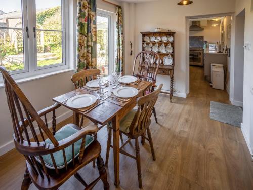 a dining room with a wooden table and chairs at Earsdon Cottage in Ireby