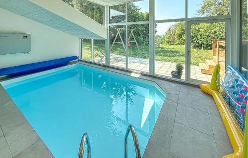 a swimming pool in a house with a large window at Lovely Home In Ebeltoft With Sauna in Ebeltoft