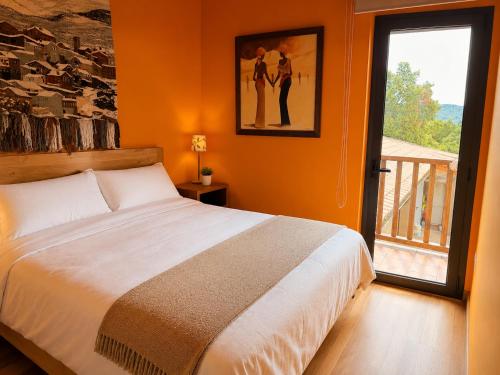 a bedroom with a bed and a large window at Hotel Villaro Del Bosc in Freixinet