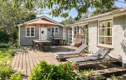 a patio with chairs and a table and an umbrella at Cozy Home In Hundested With Kitchen in Hundested