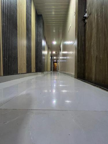 a hallway of a building with a white floor at Hotel al raihan in Mumbai