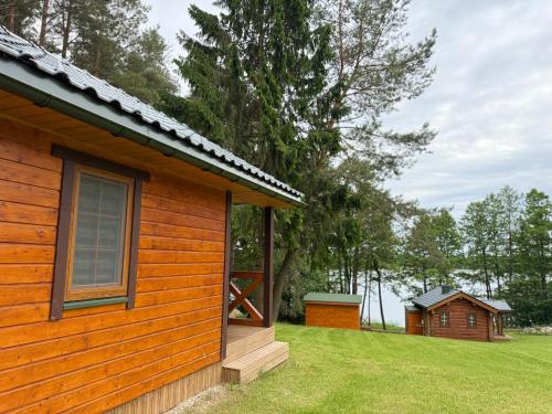 a wooden cabin with a window on the side of it at Piliakalnio Sodyba in Ilgininkai