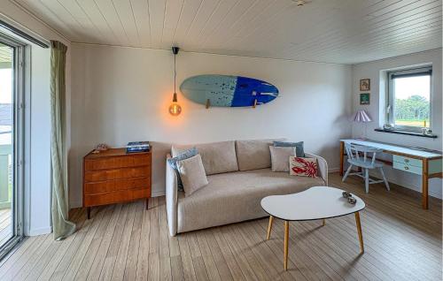 a living room with a couch and a surfboard on the wall at Nice Apartment In Hanstholm With Wifi in Hanstholm