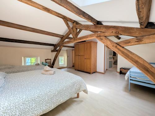 a bedroom with a bed and wooden beams at Clos de Beauregard in Cirière