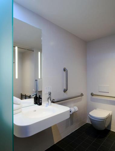 a bathroom with a white sink and a toilet at citizenM Washington DC Georgetown in Washington, D.C.