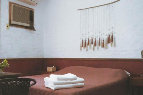 a room with a bed with towels on it at Hotel Village Termas de Dayman in Termas del Daymán