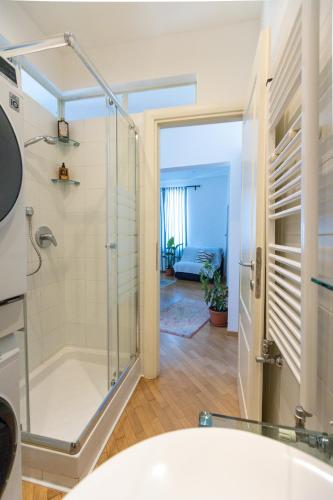 a bathroom with a shower and a white tub at Nik apartment in Genoa