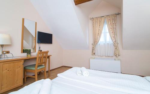 a bedroom with a desk and a bed and a computer at Gastland M1 Hotel & Conference Center in Páty