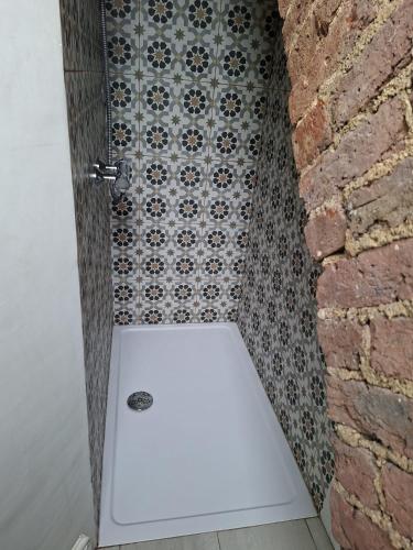 a bathroom with a shower with a tile wall at Castle Room in Windsor