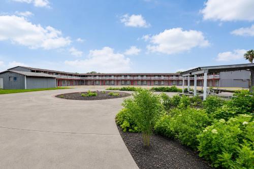 a building with a courtyard with flowers and plants at Valley Motel Corpus Christi Near Airport I 37 in Corpus Christi
