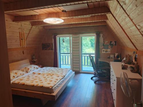 a bedroom with a bed and a large window at Chata Moniela in Drietoma