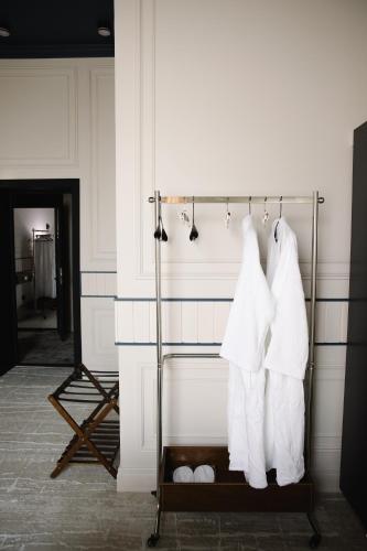 a towel rack with white robes hanging on a wall at Lumen in Kostanay