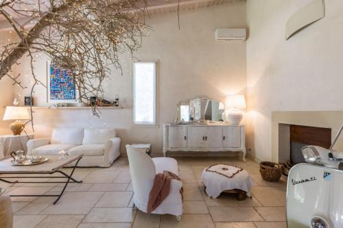 a living room with white furniture and a fireplace at Villa Reginella - Rive del Salento in Lecce