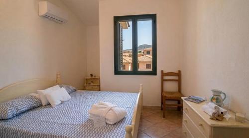 a bedroom with a bed and a window at Appartamento Eli in Valledoria