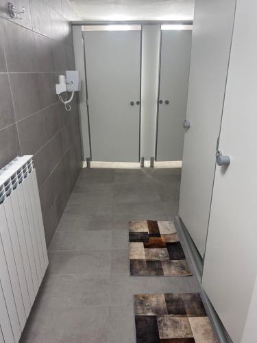 a bathroom with a hallway with doors and a tile floor at Casa Grevo Bed and Breakfast in Cedegolo