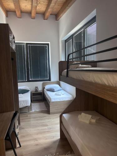 a room with two bunk beds and two windows at Casa Grevo Bed and Breakfast in Cedegolo