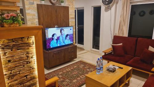 a living room with a flat screen tv and a couch at Murree Spring Apartment in Murree
