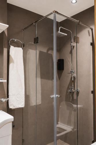 a shower with a glass door in a bathroom at Hôtel Aguelmam in Khenifra