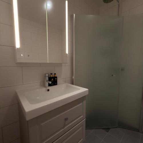 a bathroom with a white sink and a shower at Orrvägen in Torshälla