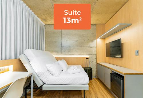a hospital room with a white bed and a tv at Linked Batel Curitiba by Xtay in Curitiba