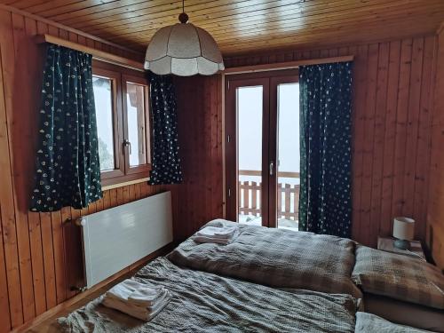 a bedroom with a bed and two windows at Chalet Bisse Neuf in Saint-Luc