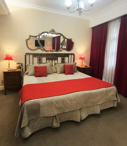 a bedroom with a large bed with a mirror on the wall at Tanguero Hotel Boutique Antique in Buenos Aires