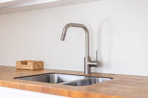 a kitchen sink with a faucet on a counter at Cozy Waterfront Getaway for a Perfect Holiday in Langweer
