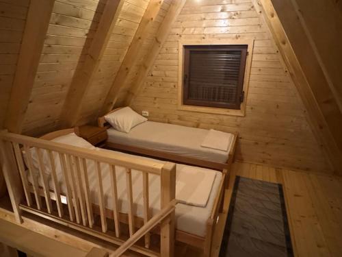 an attic room with two beds and a window at Brvnare Sadba 